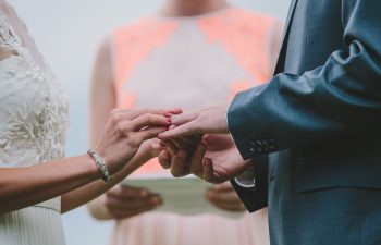 bride putting ring onto groom's hand