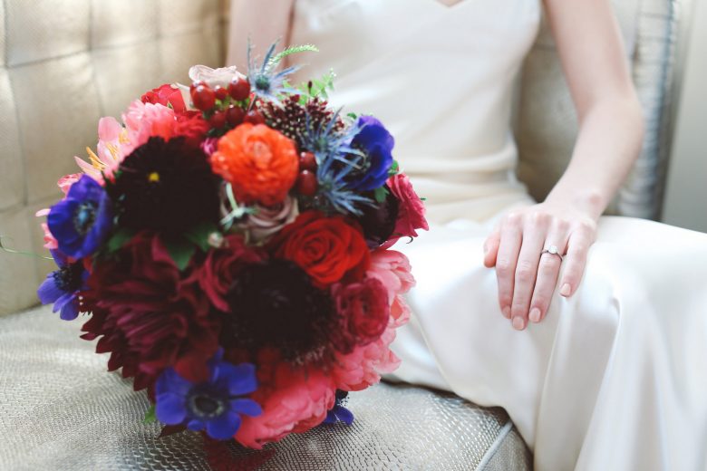 bride holding wedding bouquet and displaying engagement ring