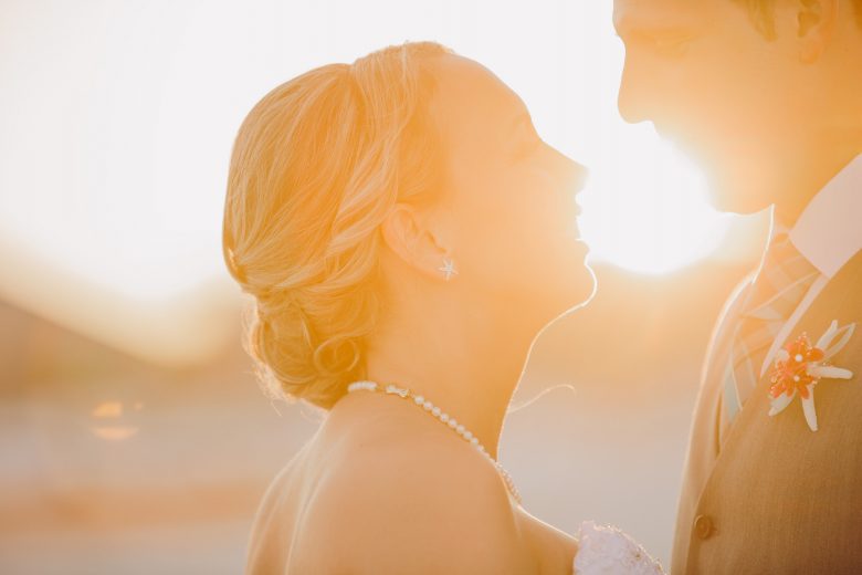 bride and groom smiling at sunset