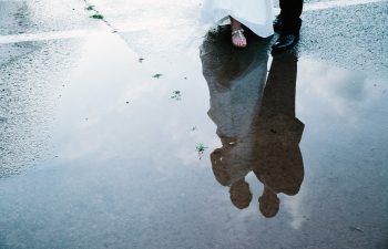 bride and groom reflected in pool of water