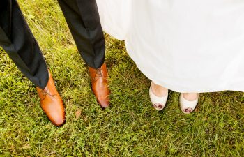 bride and groom standing in grass