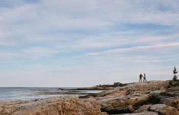 man and woman standing at the ocean