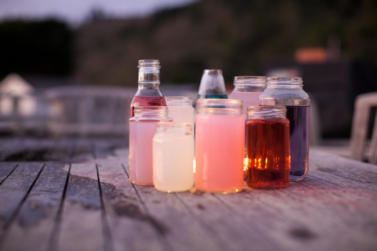 clear bottles with colored water and lights make a lovely version of wine bottle centerpieces for your wedding