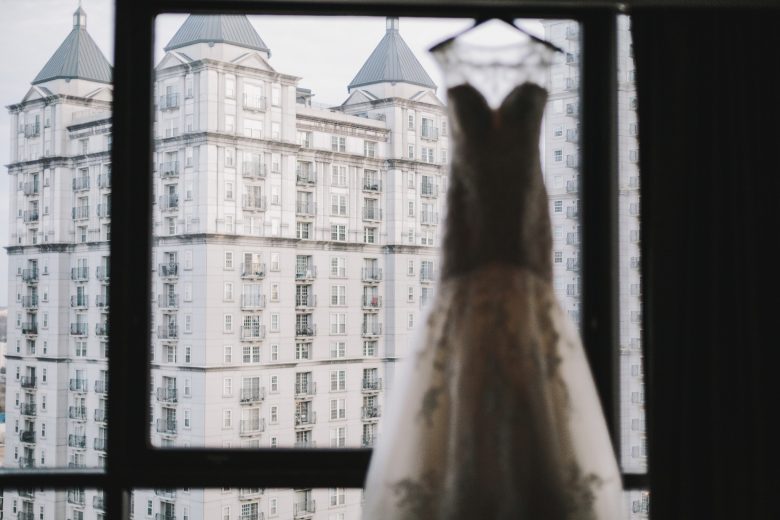 wedding dress hanging in front of city background