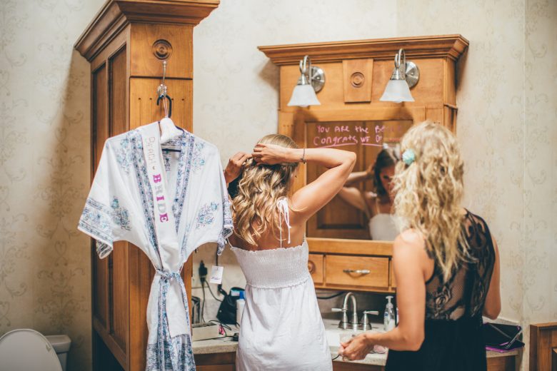 bride and bridesmaid getting ready before wedding