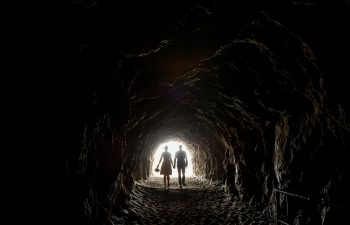 man and woman silhouetted in cave