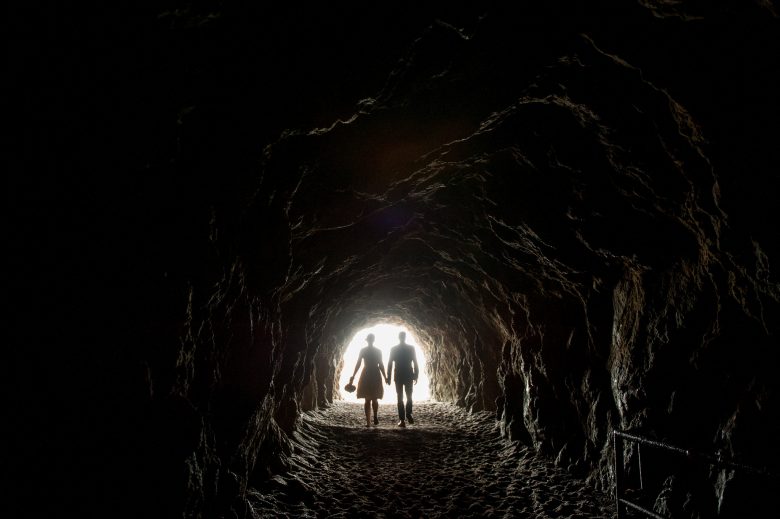 man and woman silhouetted in cave
