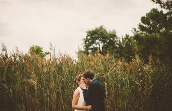 bride and groom kissing in front of corn