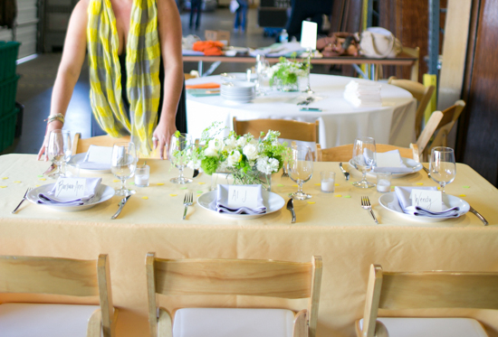 A woman sets a dining table for wedding rentals.