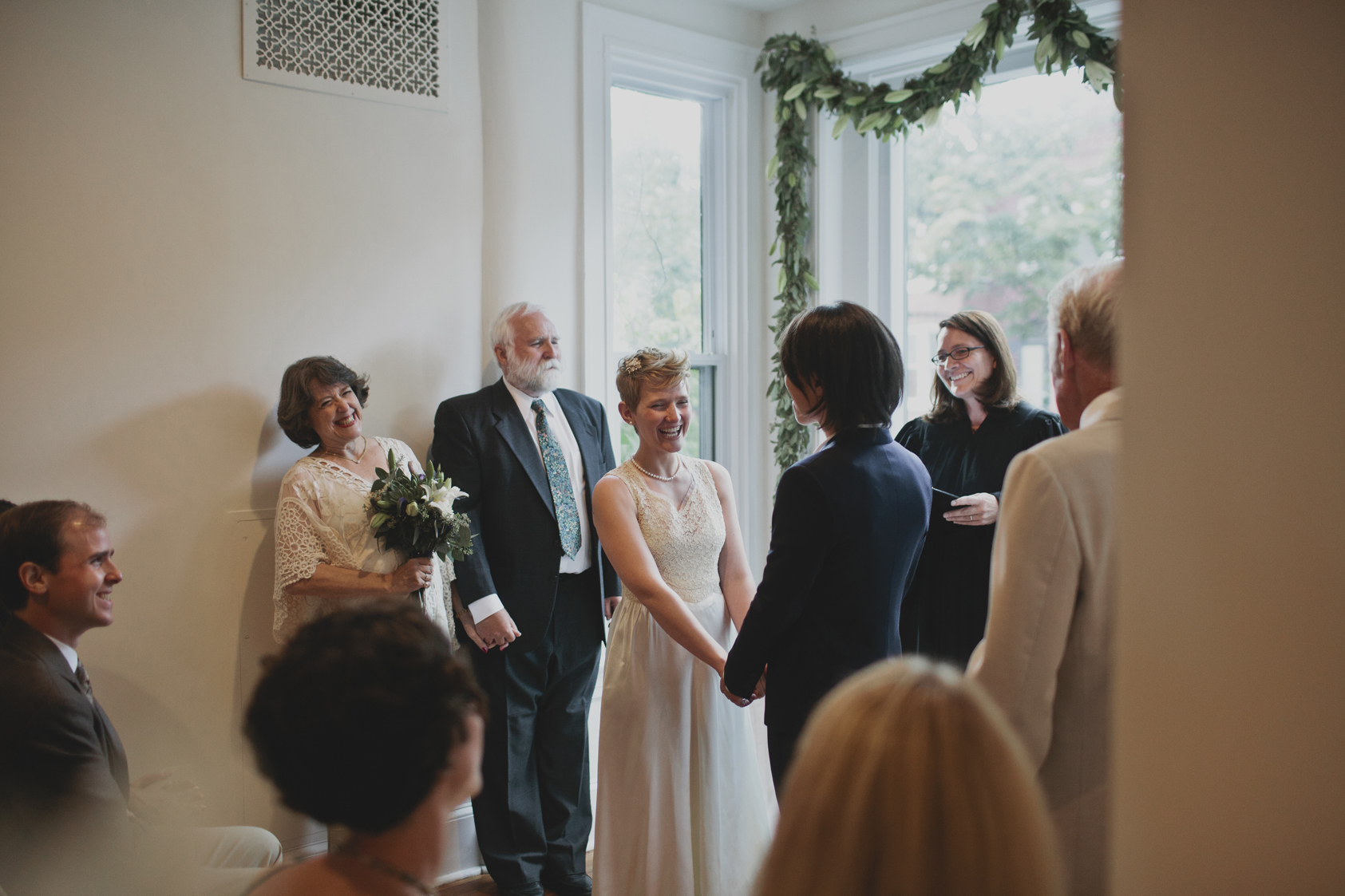 A couple getting married in a nook next to the window in their home