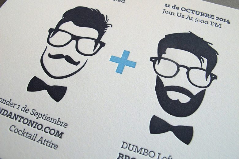 Letterpress wedding invitation by Thomas Printers featuring caricatures of two grooms, both with glasses and bow ties, one with a mustache, and the other with a full beard with a blue plus sign between them