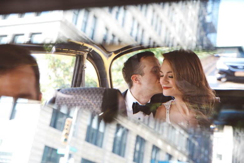 bride and groom in the back of a cab