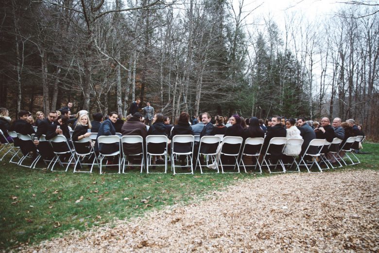 Many people sitting in folding chairs outside turned to the photographer behind them