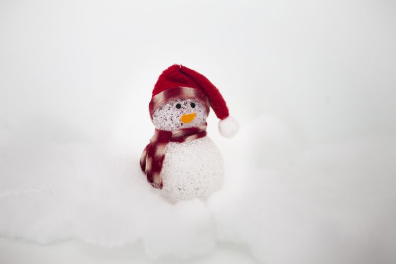 Small glass snowman with red scarf and santa hat surrounded by cotton balls | A Practical Wedding
