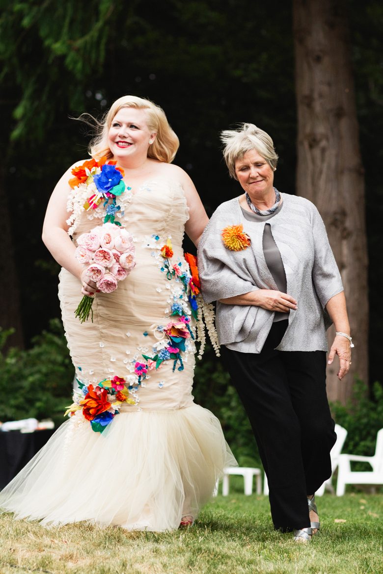 Blonde in cream tulle wedding gown and peony bouquet walking in grass with mother | A Practical Wedding
