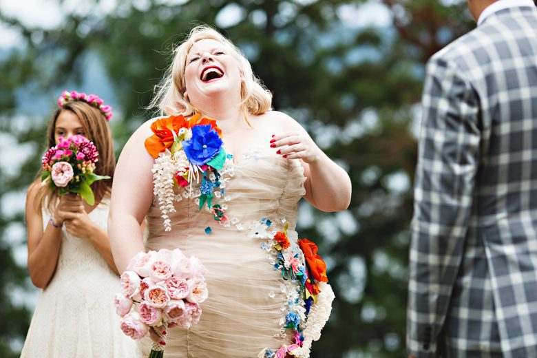 Girl with fabric flower dress laughing, girl in background with pink flower crown and matching bouquet | A Practical Wedding