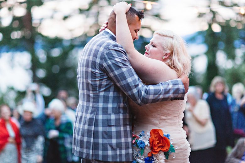 Man in plaid, Aham and woman in cream, Lindy West, holding one another closely during the first dance | A Practical Wedding 