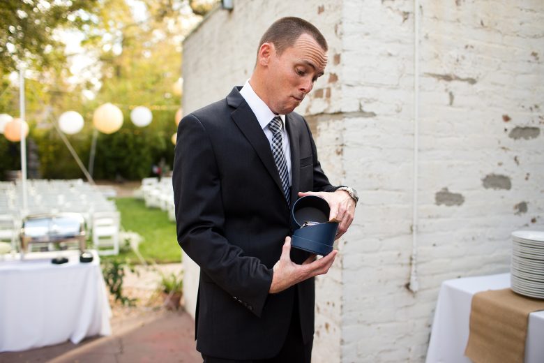 Groom looking at gift on his wedding day