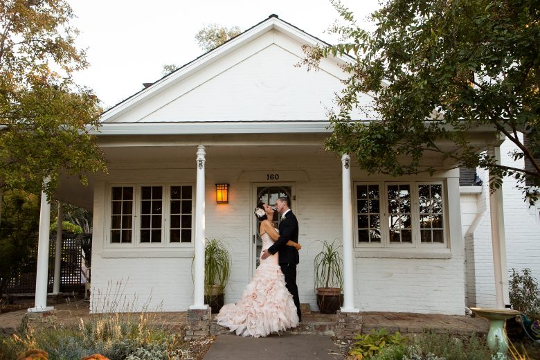 Bride and groom in front of house on wedding day