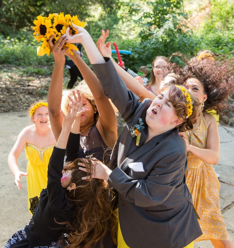 Women trying to catch bridal bouquet of sunflowers
