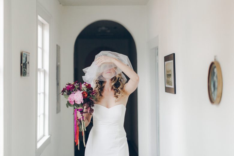 bride in veil and dress holding flowers