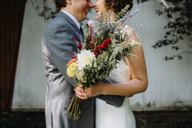 couple smiling with wedding flowers