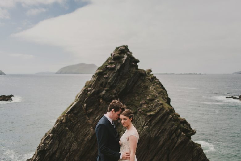 couple by ocean on wedding day