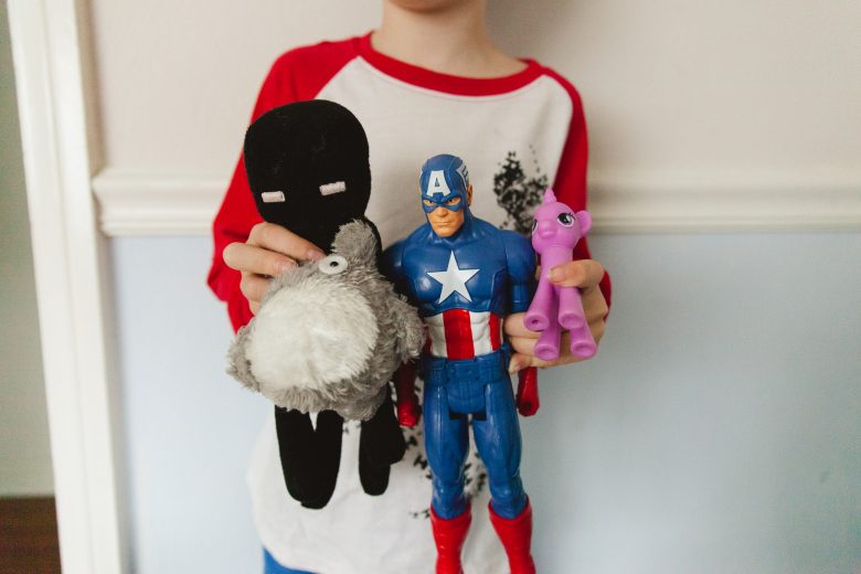 kid's torso with stuffed animals and action hero dolls and pony dolls