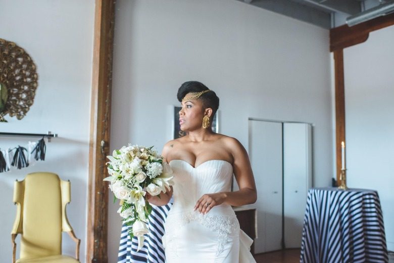 black bride with a strapless white Truly by Zac Posen dress and gold chain headband