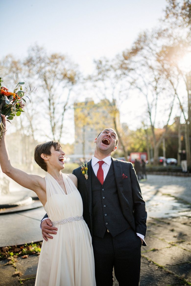 bride and groom laughing in the park