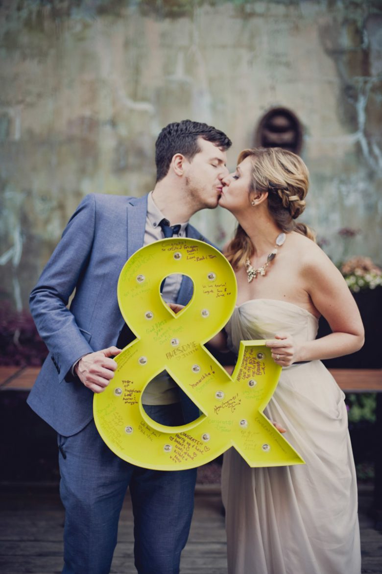 Couple holding yellow ampersand sign