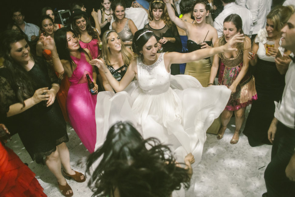 a bride dances during the reception, surrounded by her guests