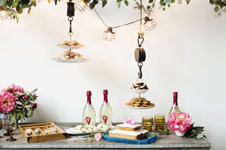 Dessert table with hanging foliage and lights and cookies