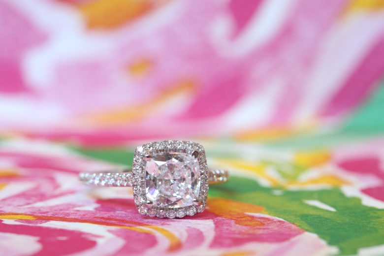 Large halo diamond engagement ring on bright pattern backdrop