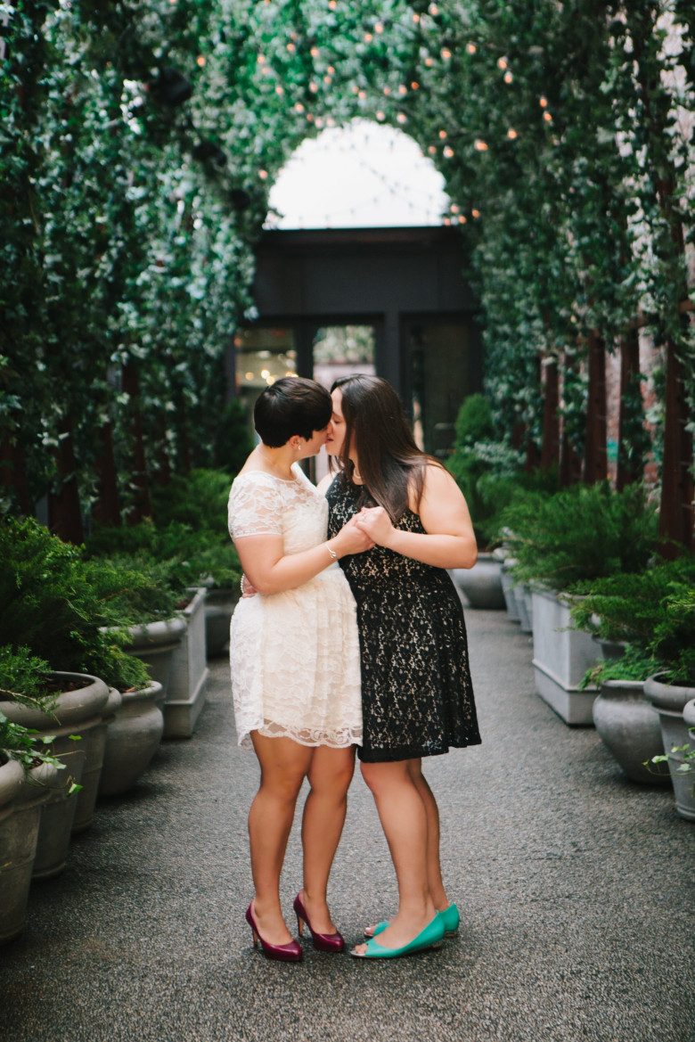 lesbian couple kissing on a pathway in New York City 