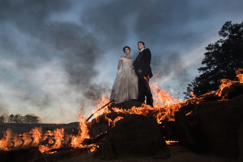 bride and groom standing in flames