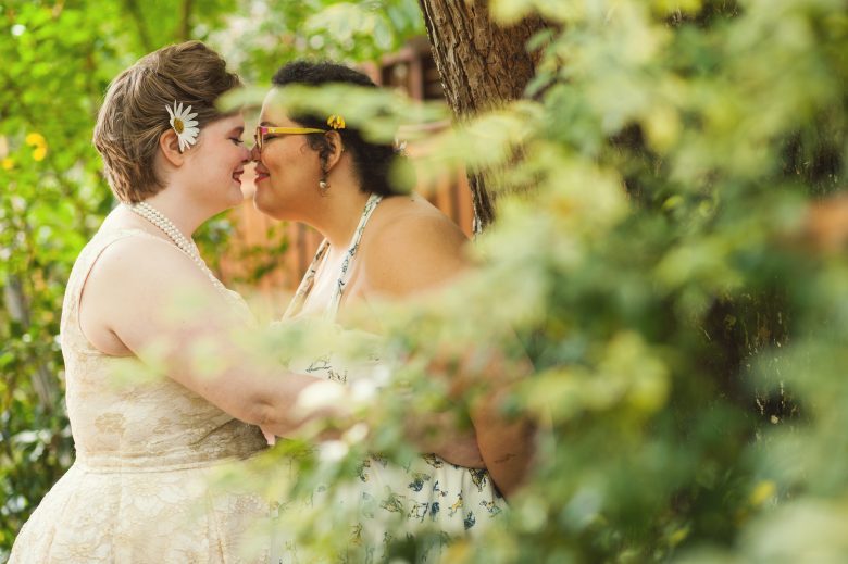 two brides kissing one another on wedding day