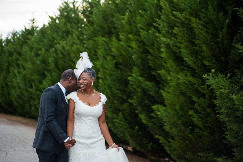 bride and groom in front of bushes and trees