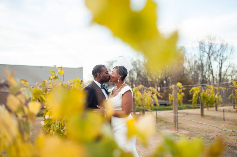bride and groom kissing in field with yellow flowers
