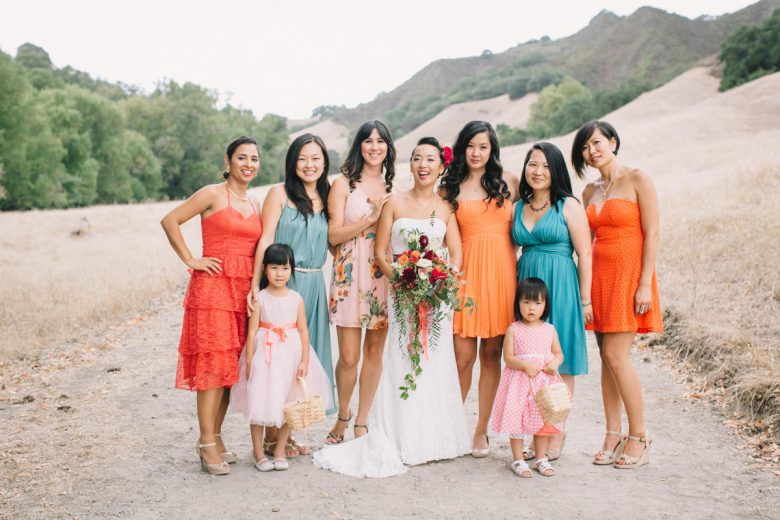 bride standing with bridal party and flower girls