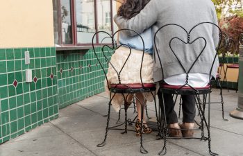 man and woman sitting in heart backed chairs