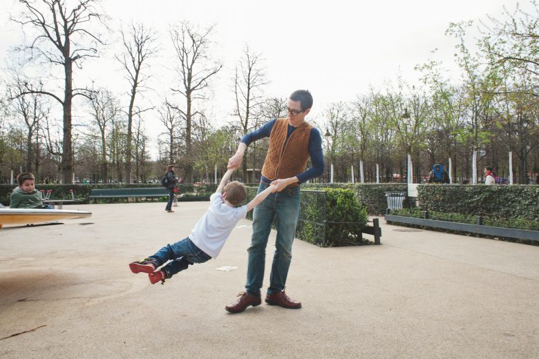 father spinning his son in the tuileries garden in paris