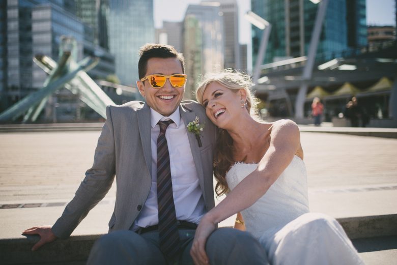 Groom in reflective sunglasses and laughing bride