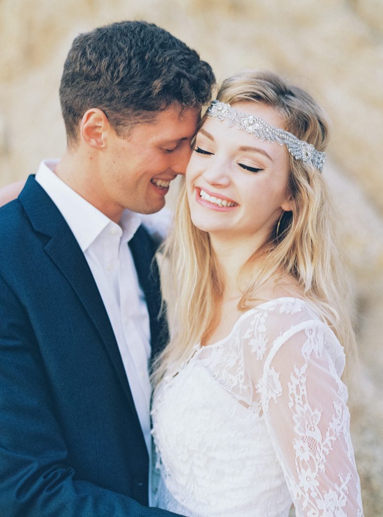 Man in suit and girl with rhinestone crown and lace shirt laughing together