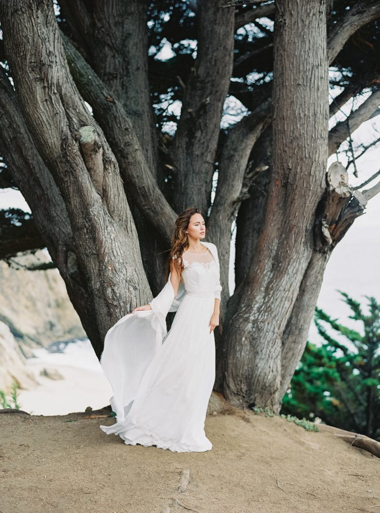 girl in white bridal seperates in front of tree