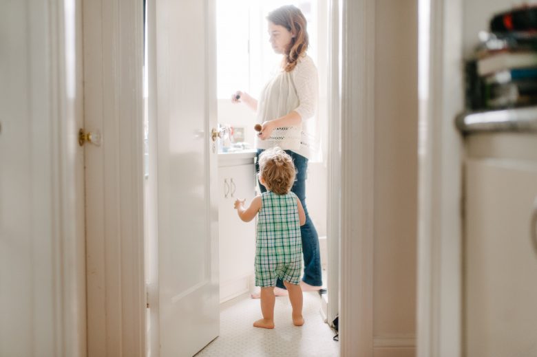 Mother with small child in white bathroom
