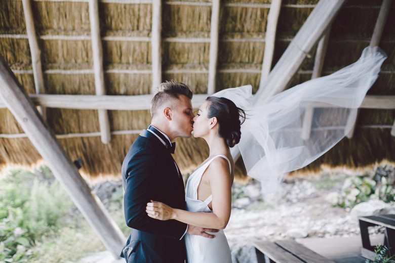 bride and groom kissing in hut