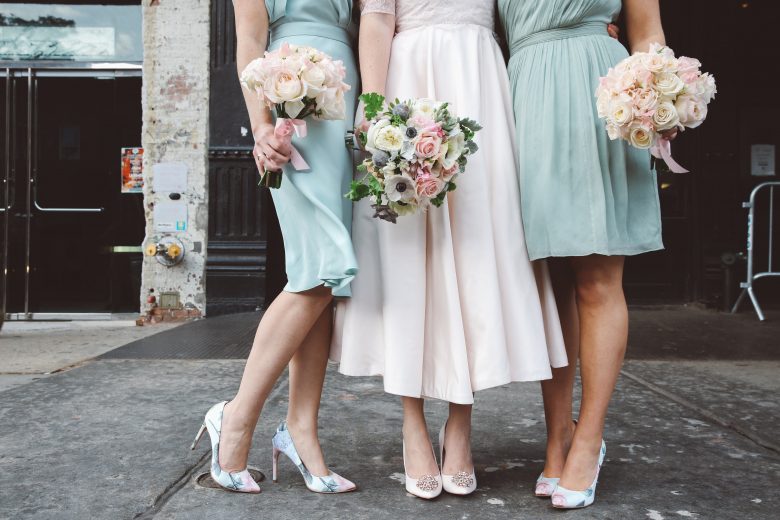 bride and bridesmaids with pastel bridesmaid dresses and flowers