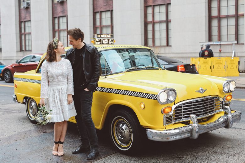 bride and groom in front of old fashioned taxi