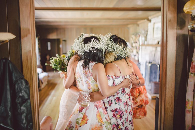 bridesmaids wearing flower crowns and hugging